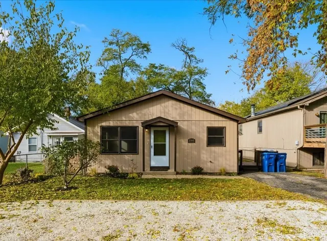 a view of a yard in front of a house with large trees