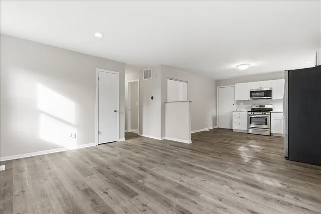 a view of kitchen with wooden floor and electronic appliances