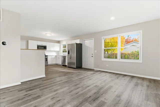 a view of empty room with wooden floor and window