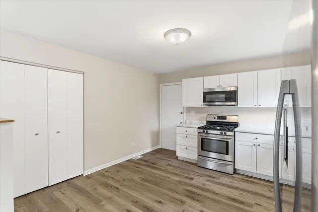 a kitchen with stainless steel appliances granite countertop a stove a refrigerator and a microwave