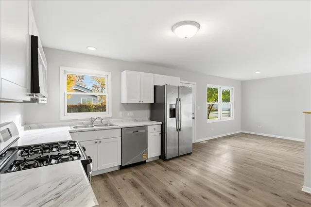a kitchen with stainless steel appliances granite countertop a stove a sink and a refrigerator