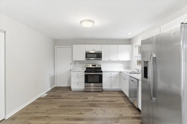 a kitchen with granite countertop a refrigerator stove and oven