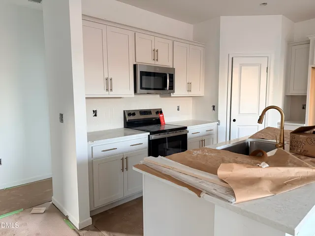 a kitchen with white cabinets and sink