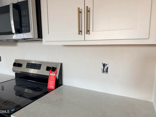 a kitchen with white cabinets and a stove