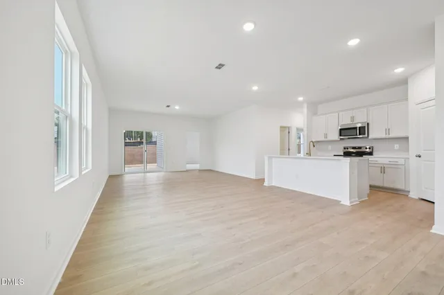 an empty room with a kitchen and a sink