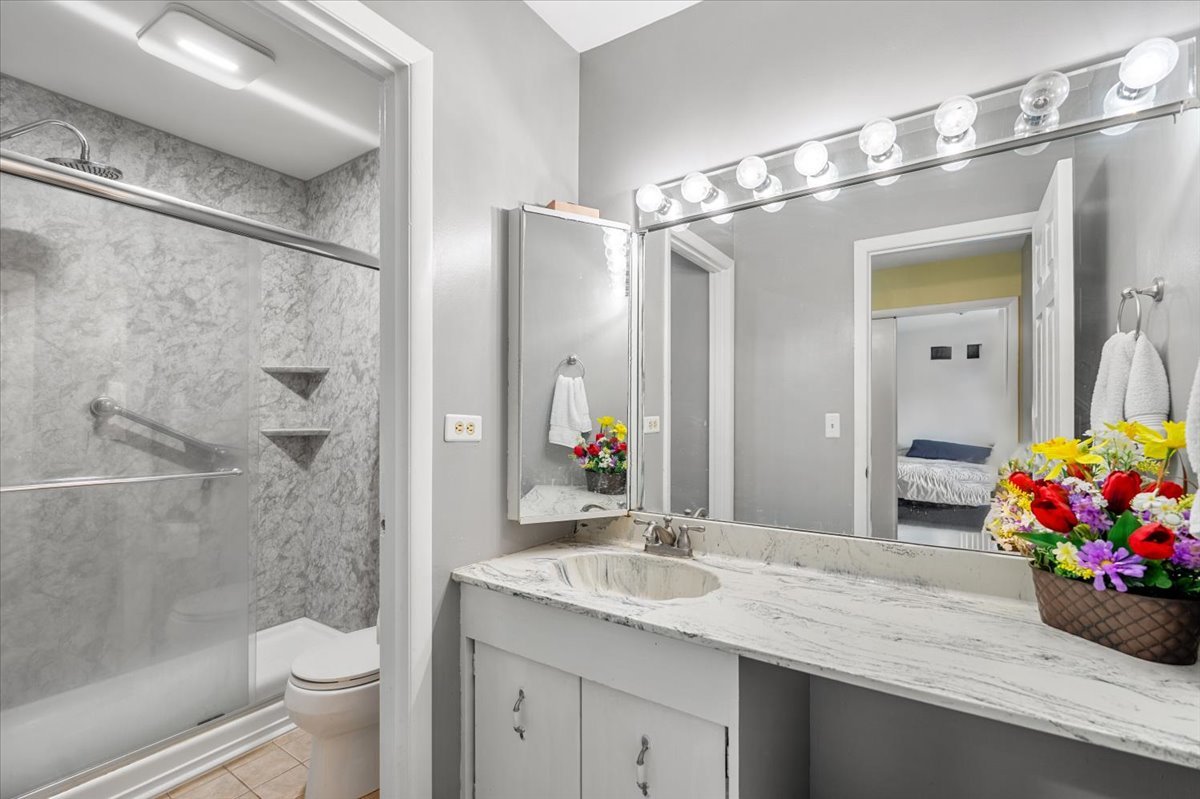 642 Dunham Road Gurnee, IL 60031 - Photo 14 of 33 a bathroom with a granite countertop shower sink vanity mirror and toilet