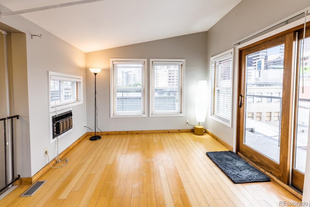 1940 Blake Street, Unit 301 Denver, CO 80202 - Photo 24 of 25 a view of an empty room with a window and wooden floor