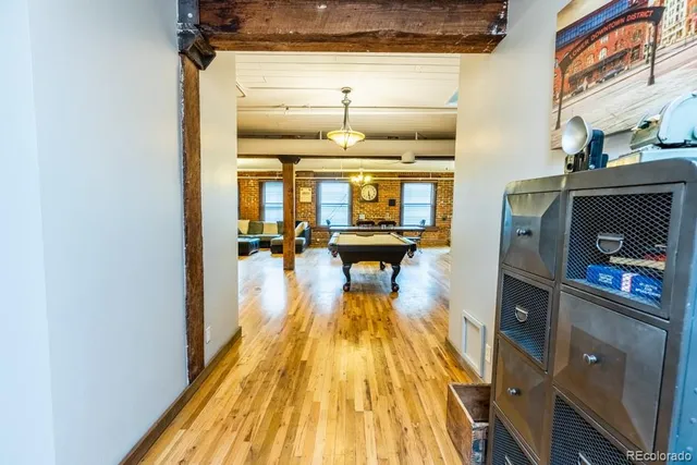 a dining hall with wooden floor and a fireplace
