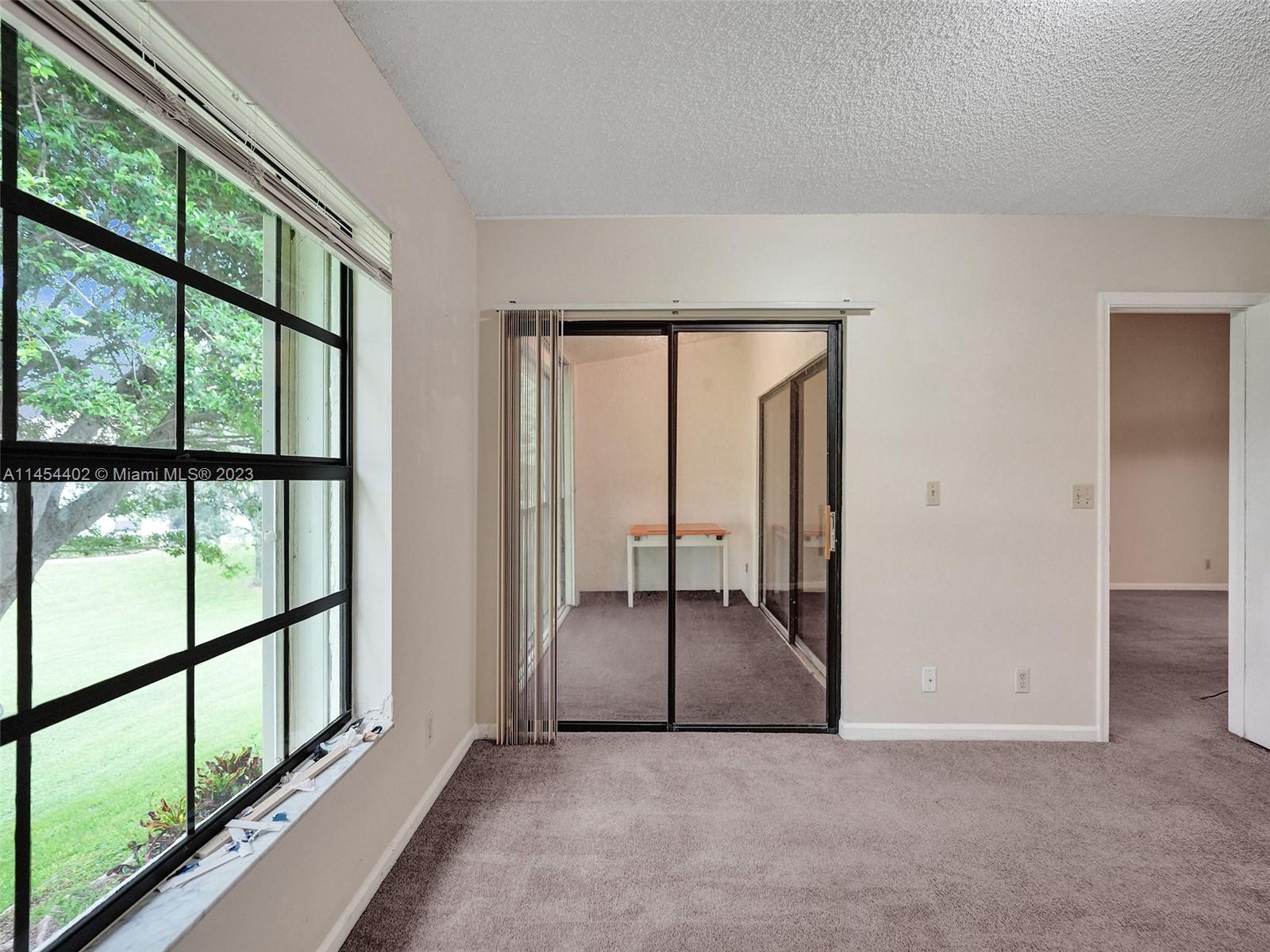 321 Olivewood Place, Unit O221 Boca Raton, FL 33431 - Photo 12 of 56 an empty room with sliding glass door and mountain view