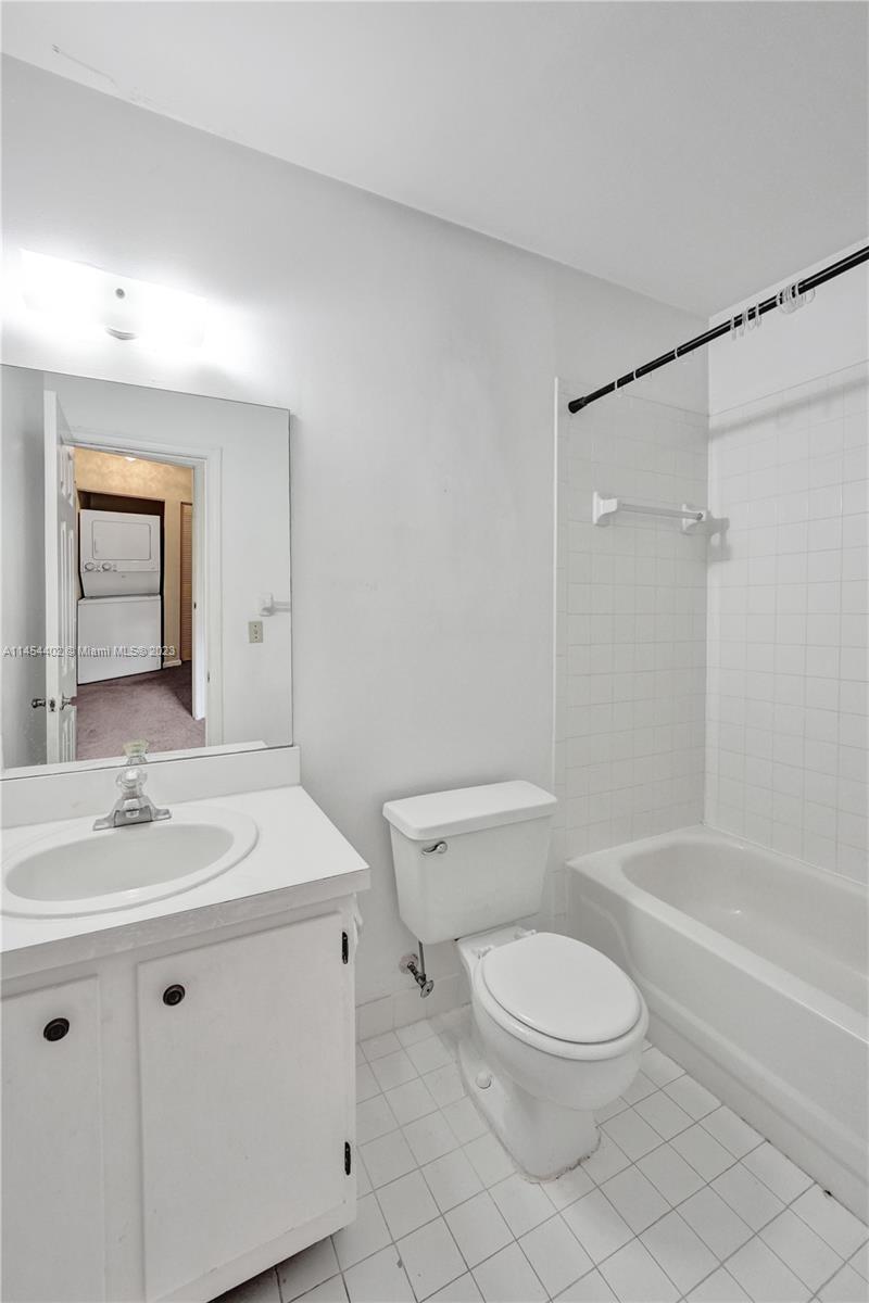 321 Olivewood Place, Unit O221 Boca Raton, FL 33431 - Photo 15 of 56 a bathroom with a toilet a sink a mirror and vanity
