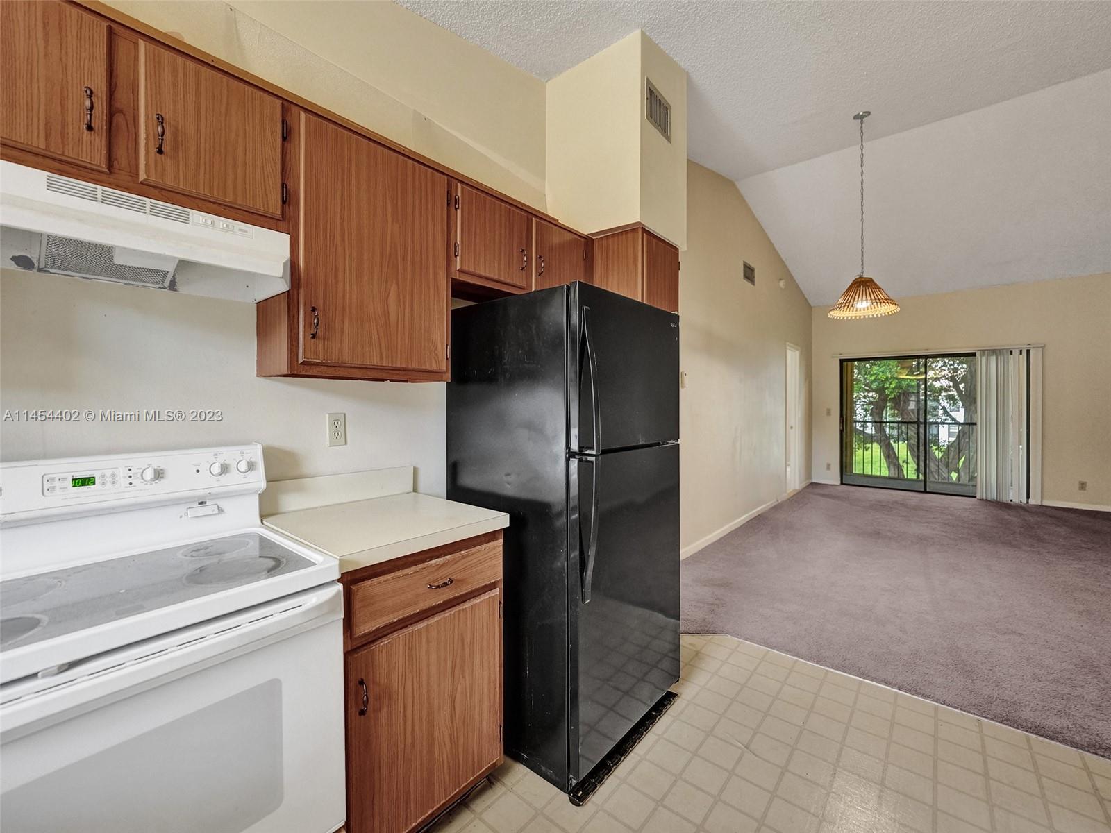321 Olivewood Place, Unit O221 Boca Raton, FL 33431 - Photo 19 of 56 a kitchen with a refrigerator and a stove top oven