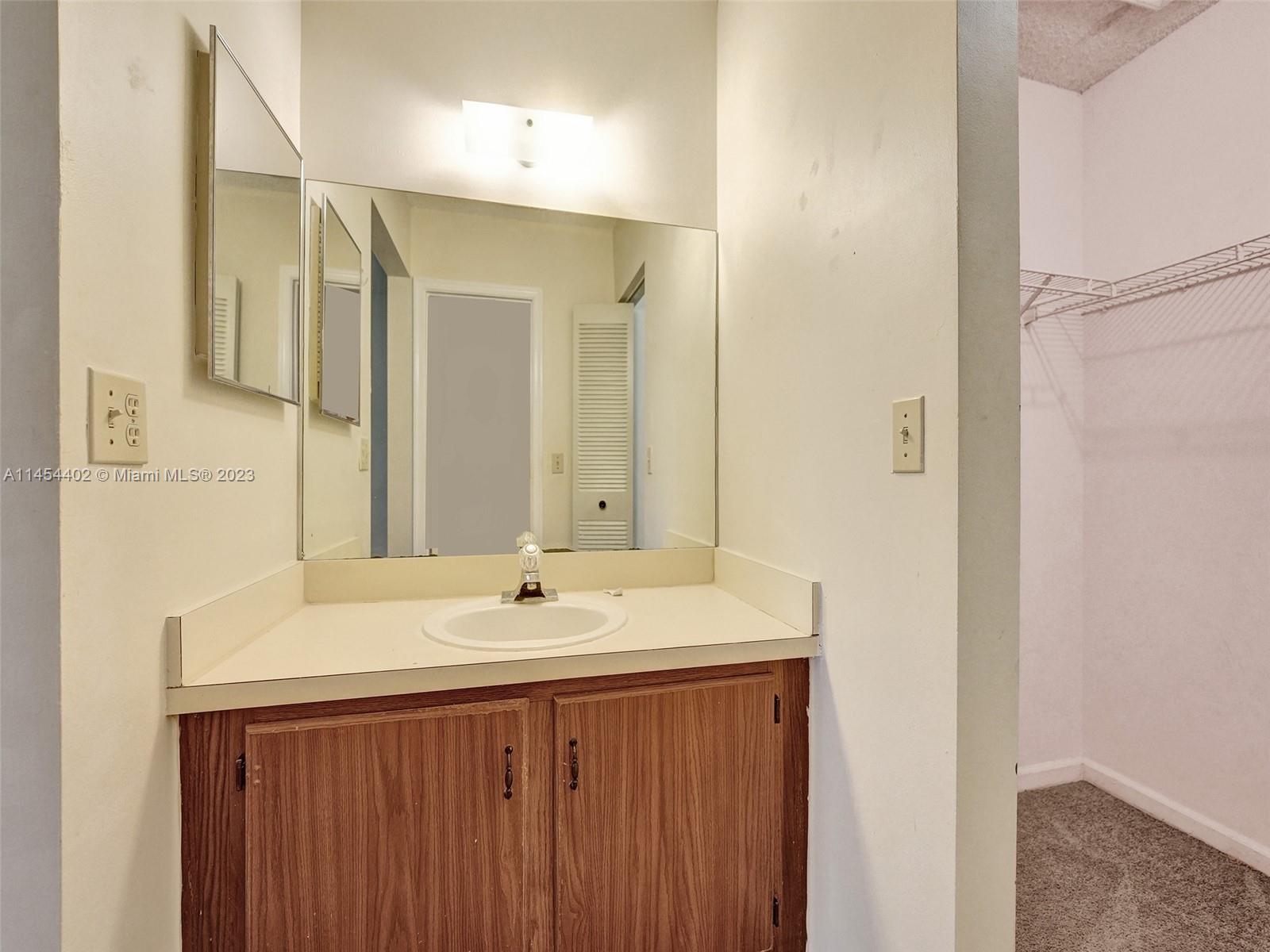 321 Olivewood Place, Unit O221 Boca Raton, FL 33431 - Photo 29 of 56 a bathroom with a sink and a mirror