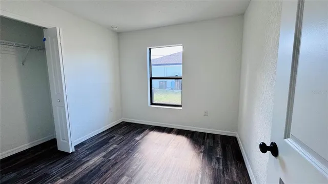 a view of a room with wooden floors and window
