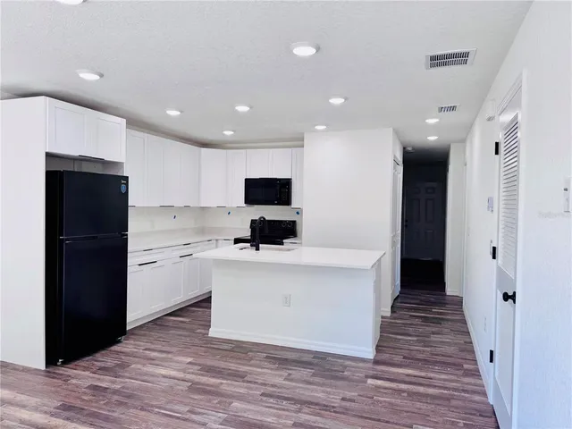 a view of kitchen with stainless steel appliances kitchen island sink and refrigerator
