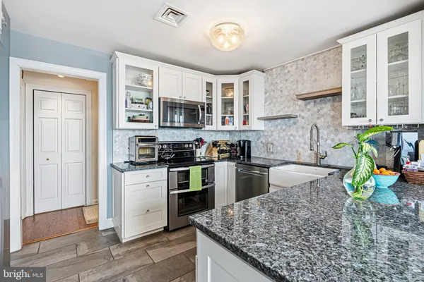 a kitchen with stainless steel appliances granite countertop a refrigerator stove microwave and sink