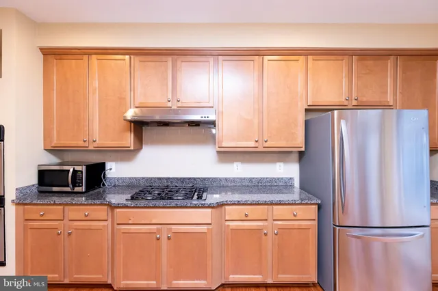 a kitchen with stainless steel appliances granite countertop a refrigerator sink and cabinets