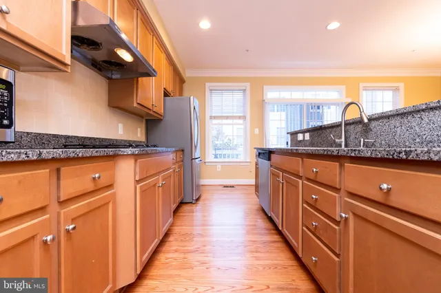 a kitchen with stainless steel appliances granite countertop a sink and a stove