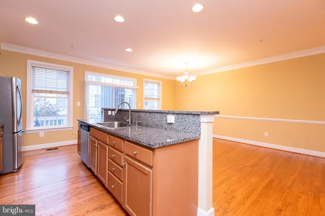 a kitchen with stainless steel appliances granite countertop a sink and a large window