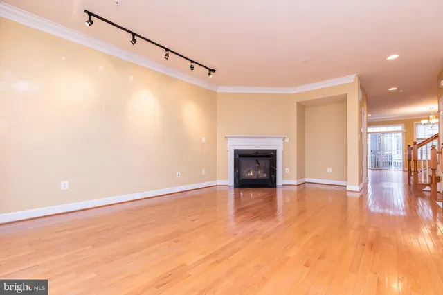 a view of empty room with wooden floor and fireplace