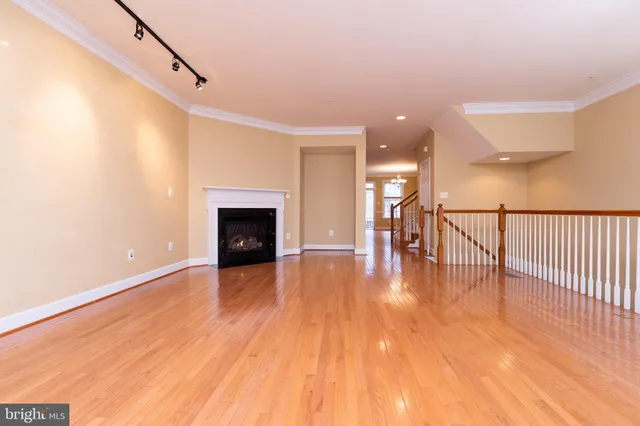 a view of a livingroom with wooden floor and a fireplace