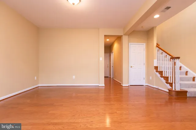 a view of an empty room with wooden floor