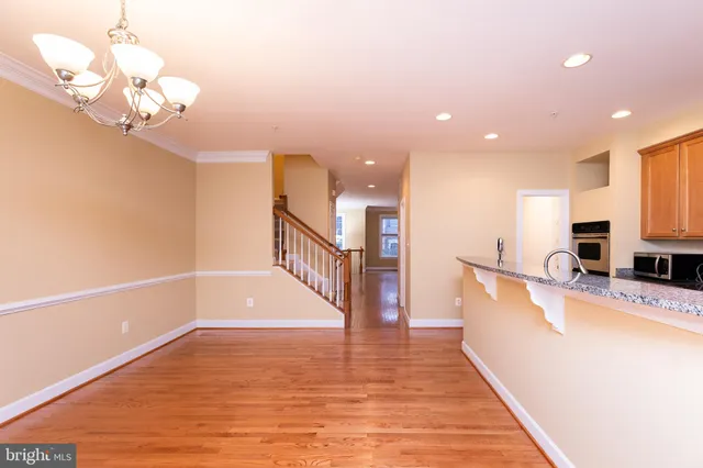 a view of a room with wooden floor and a chandelier