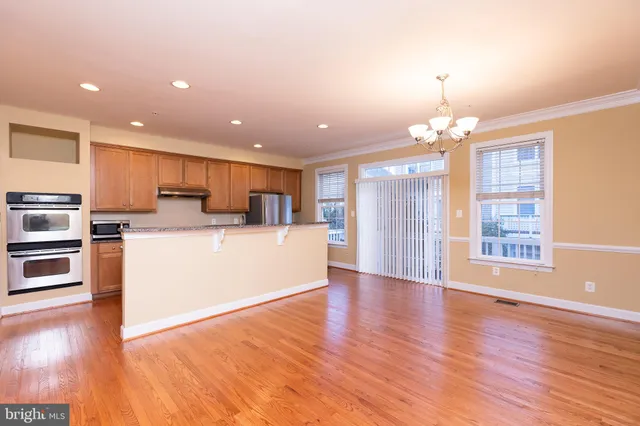 a view of kitchen with granite countertop cabinets and refrigerator