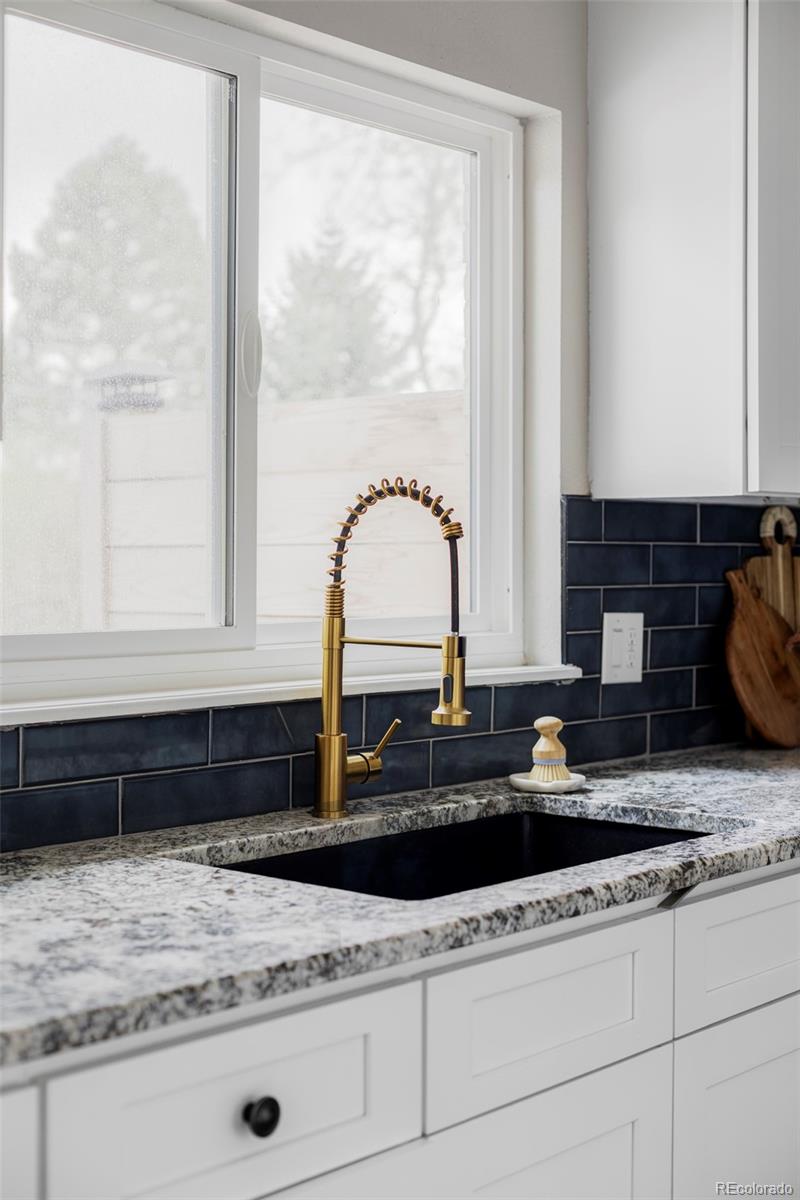 3406 South Stuart Street Denver, CO 80236 - Photo 13 of 34 a kitchen with granite countertop a sink and a window