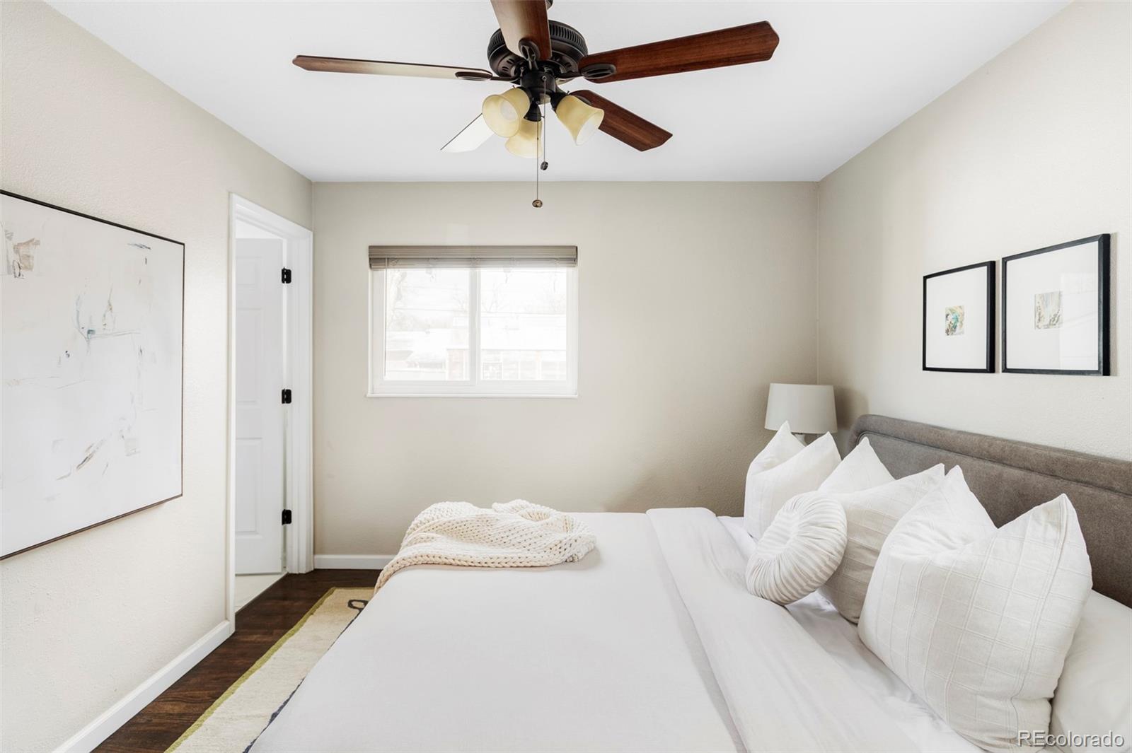 3406 South Stuart Street Denver, CO 80236 - Photo 15 of 34 a bedroom with a bed and a chandelier