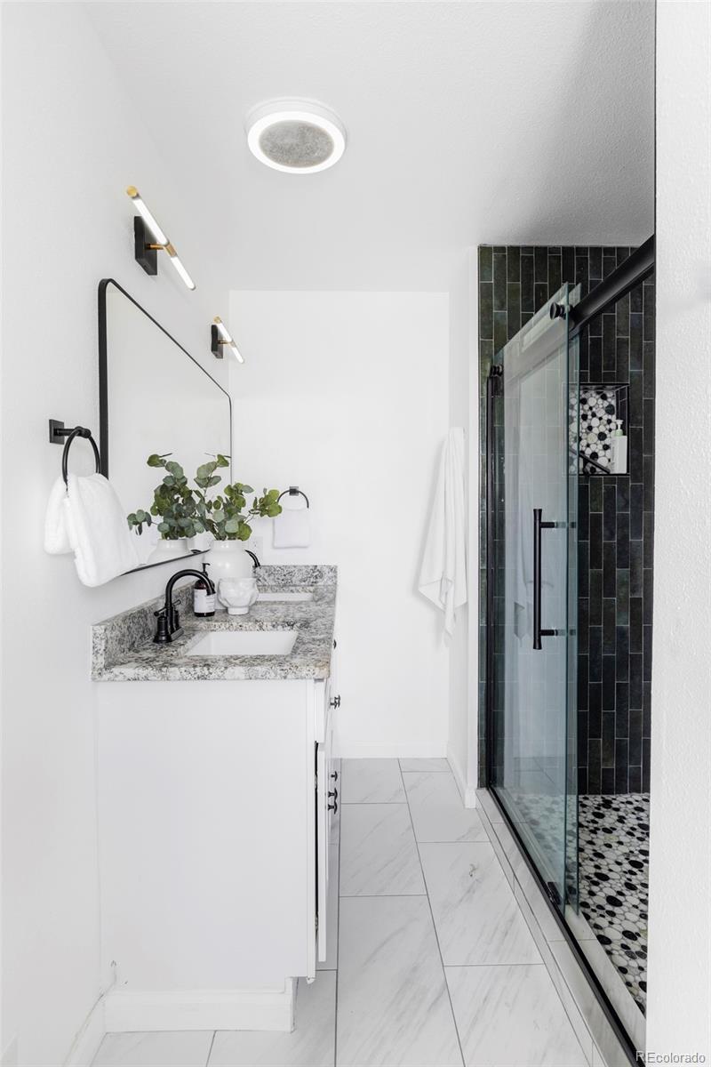 3406 South Stuart Street Denver, CO 80236 - Photo 16 of 34 a bathroom with a sink and a mirror
