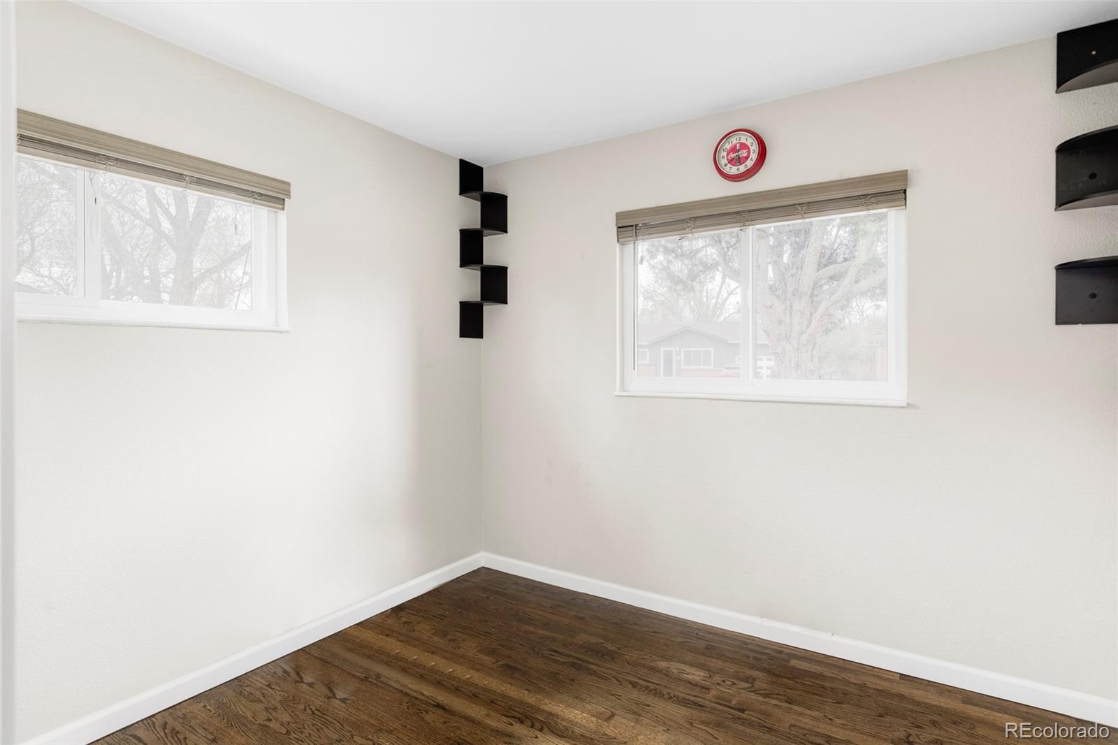 3406 South Stuart Street Denver, CO 80236 - Photo 19 of 34 an empty room with wooden floor and windows