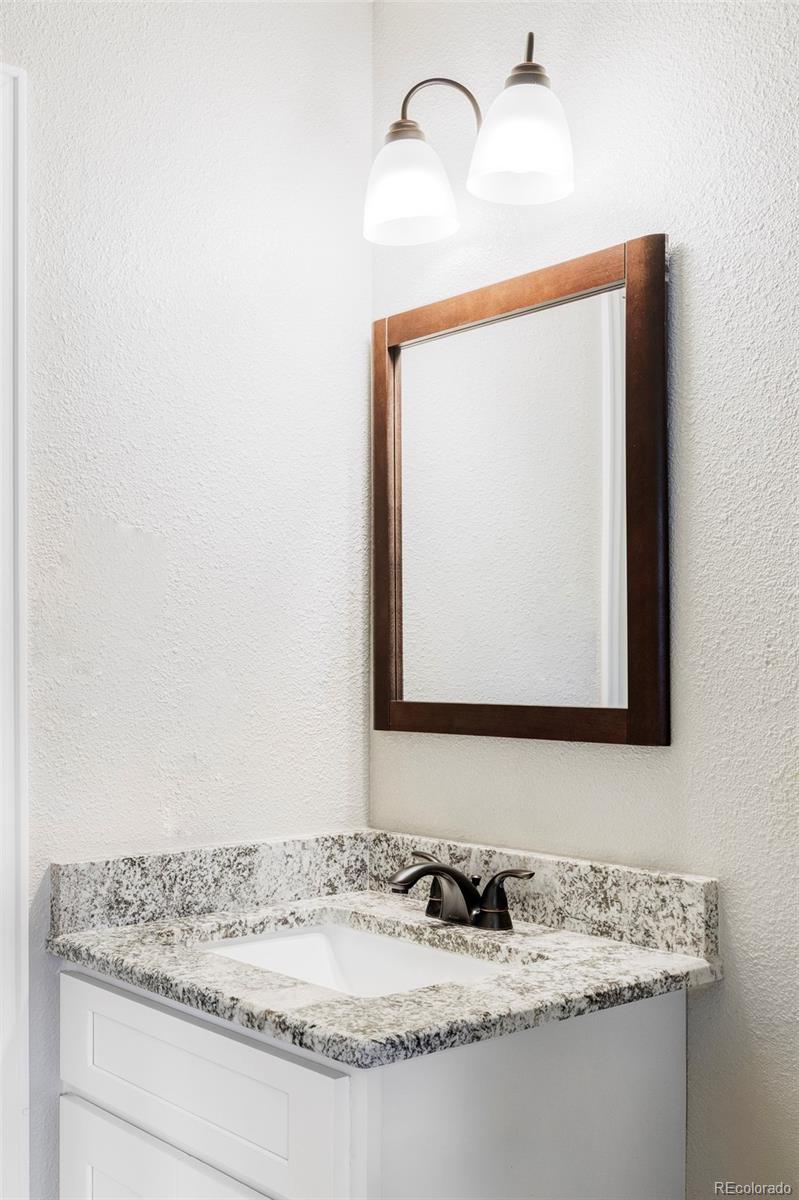 3406 South Stuart Street Denver, CO 80236 - Photo 20 of 34 a bathroom with a sink and a mirror
