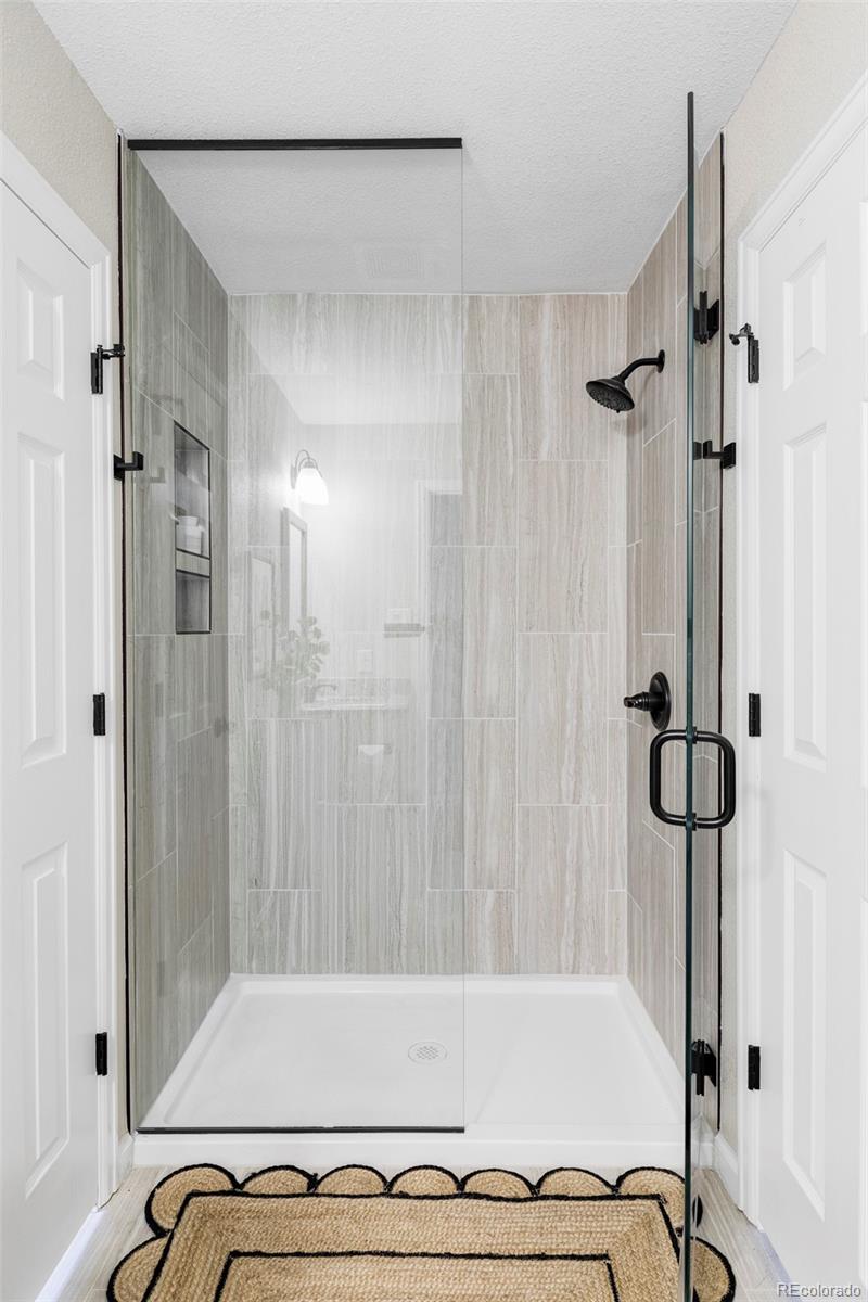 3406 South Stuart Street Denver, CO 80236 - Photo 21 of 34 a bathroom with a bathtub and a shower