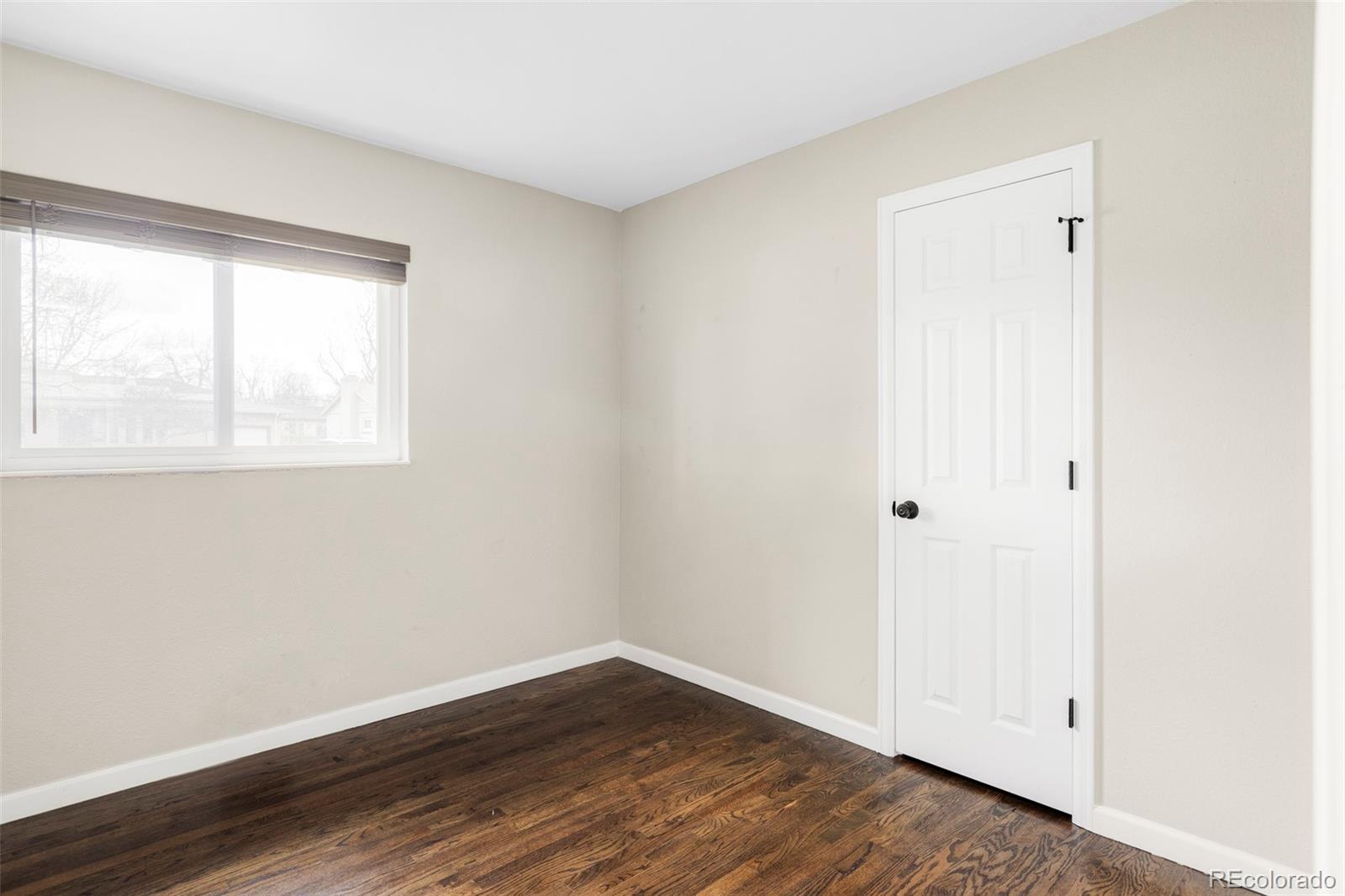 3406 South Stuart Street Denver, CO 80236 - Photo 22 of 34 an empty room with wooden floor and windows