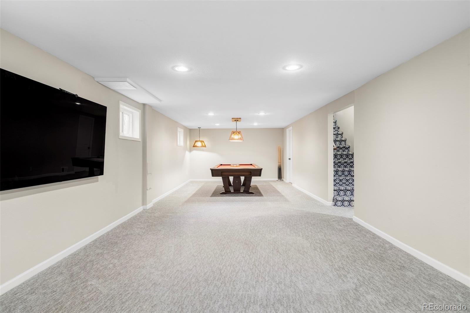 3406 South Stuart Street Denver, CO 80236 - Photo 23 of 34 a living room with furniture and a flat screen tv