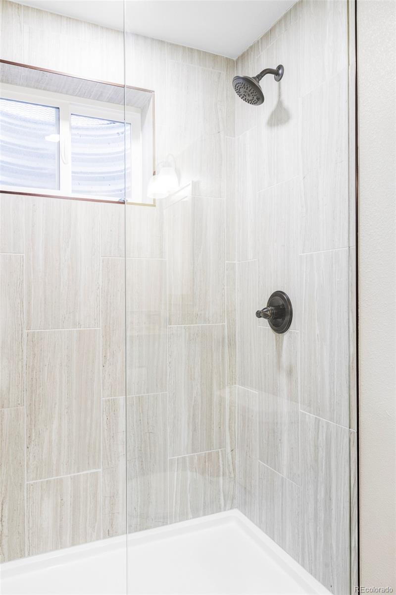 3406 South Stuart Street Denver, CO 80236 - Photo 26 of 34 a bathroom with a shower