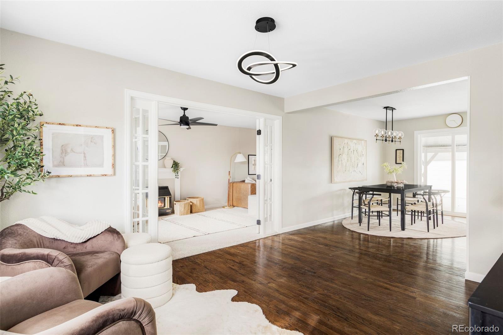 3406 South Stuart Street Denver, CO 80236 - Photo 4 of 34 a living room with furniture wooden floor and a chandelier