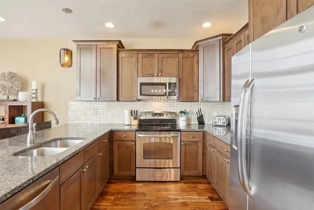a kitchen with stainless steel appliances granite countertop a refrigerator sink and cabinets
