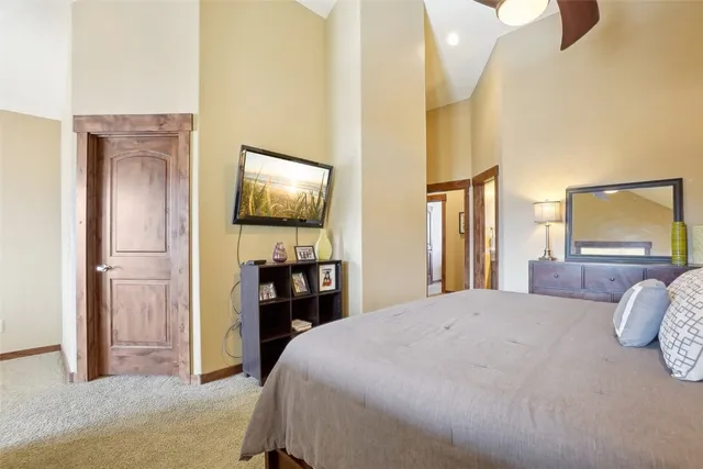 a bedroom with a bed and a flat tv screen on dresser