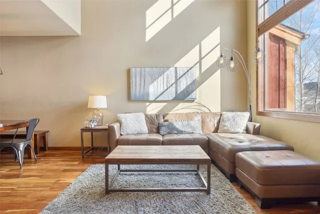 a living room with furniture wooden floor and a table