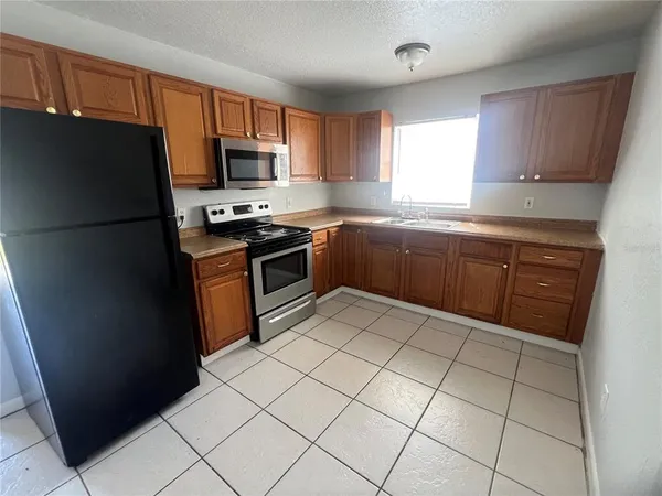 a kitchen with stainless steel appliances granite countertop a refrigerator stove a sink and a microwave