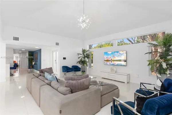a living room with furniture and a chandelier