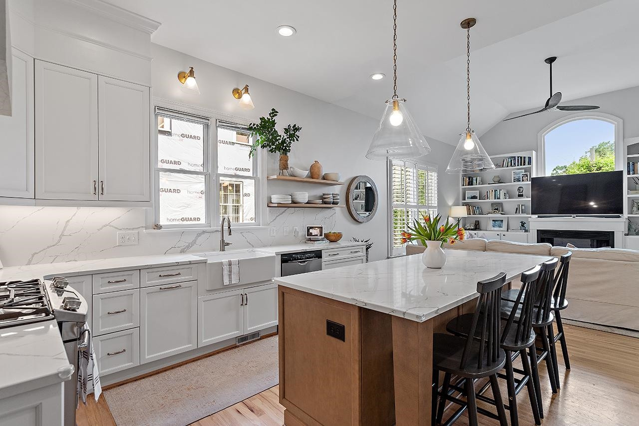 502 Cleveland Street Raleigh, NC 27605 - Photo 6 of 36 a kitchen with center island a sink dishwasher a dining table and chairs with wooden floor