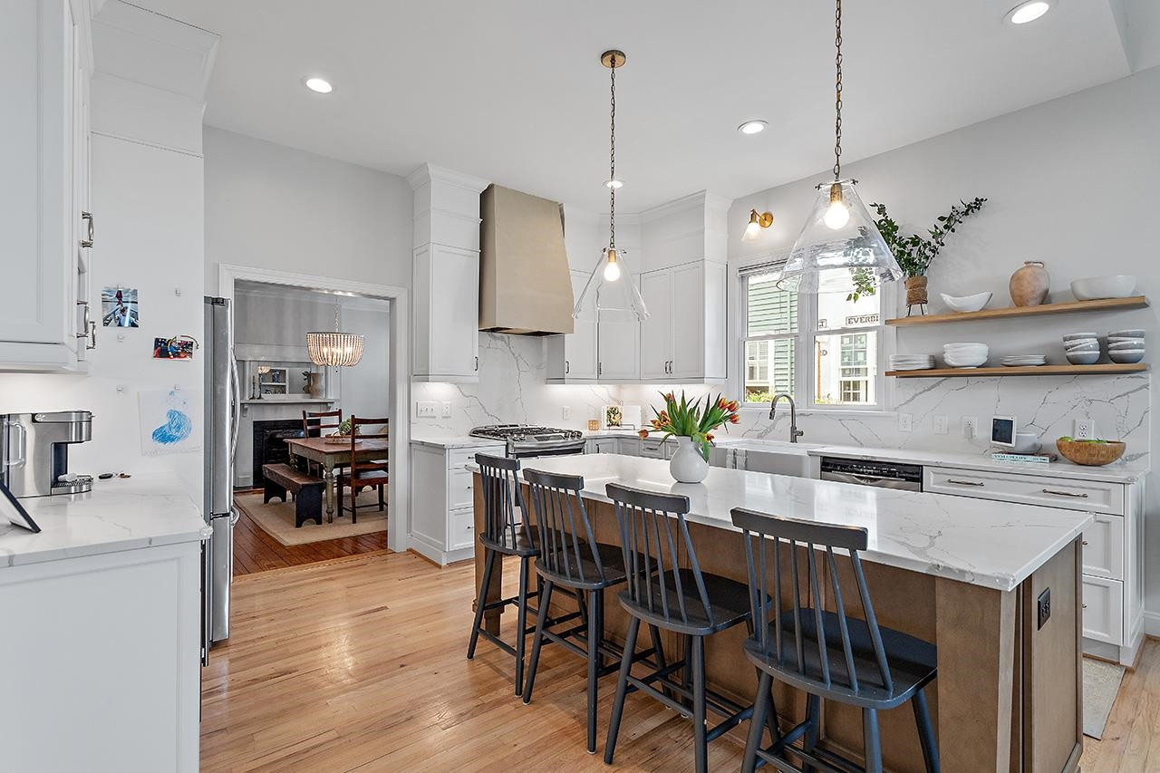 502 Cleveland Street Raleigh, NC 27605 - Photo 7 of 36 a kitchen with stainless steel appliances a kitchen island a stove a table and chairs in it