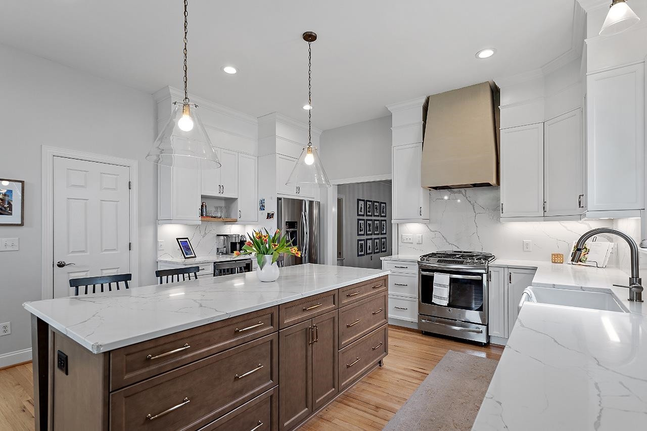 502 Cleveland Street Raleigh, NC 27605 - Photo 9 of 36 a kitchen with kitchen island a sink stainless steel appliances and cabinets