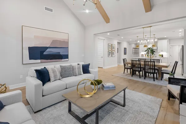 a living room with furniture a dining table and a chandelier