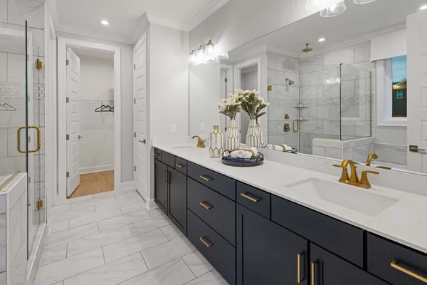 a bathroom with a double vanity sink mirror and shower