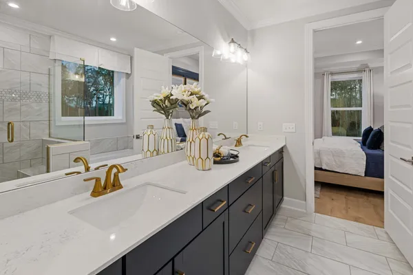 a spacious en suite bathroom with a double vanity sink and a mirror