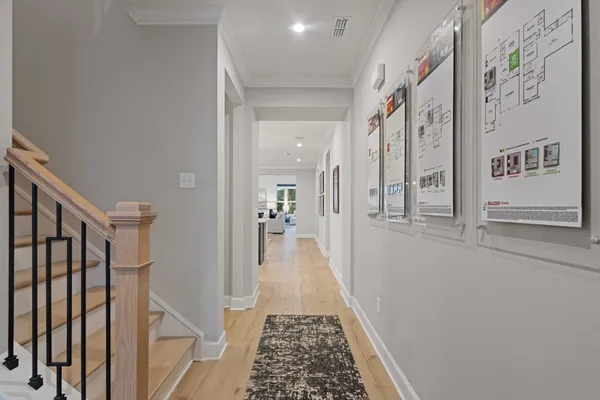 a view of a hallway with wooden floor and staircase