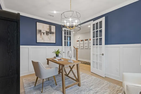 a view of a dining room with furniture a chandelier and wooden floor
